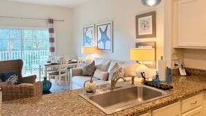 A kitchen with a granite countertop, stainless steel sink, and pendant lights. - Luxury Seven Eagles Townhome in Reunion Resort (Kissimmee)