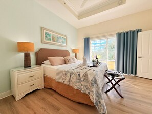 A bedroom with a bed, bedside tables, a chair, a window with curtains, and a door. - Luxury Seven Eagles Townhome in Reunion Resort (Kissimmee)