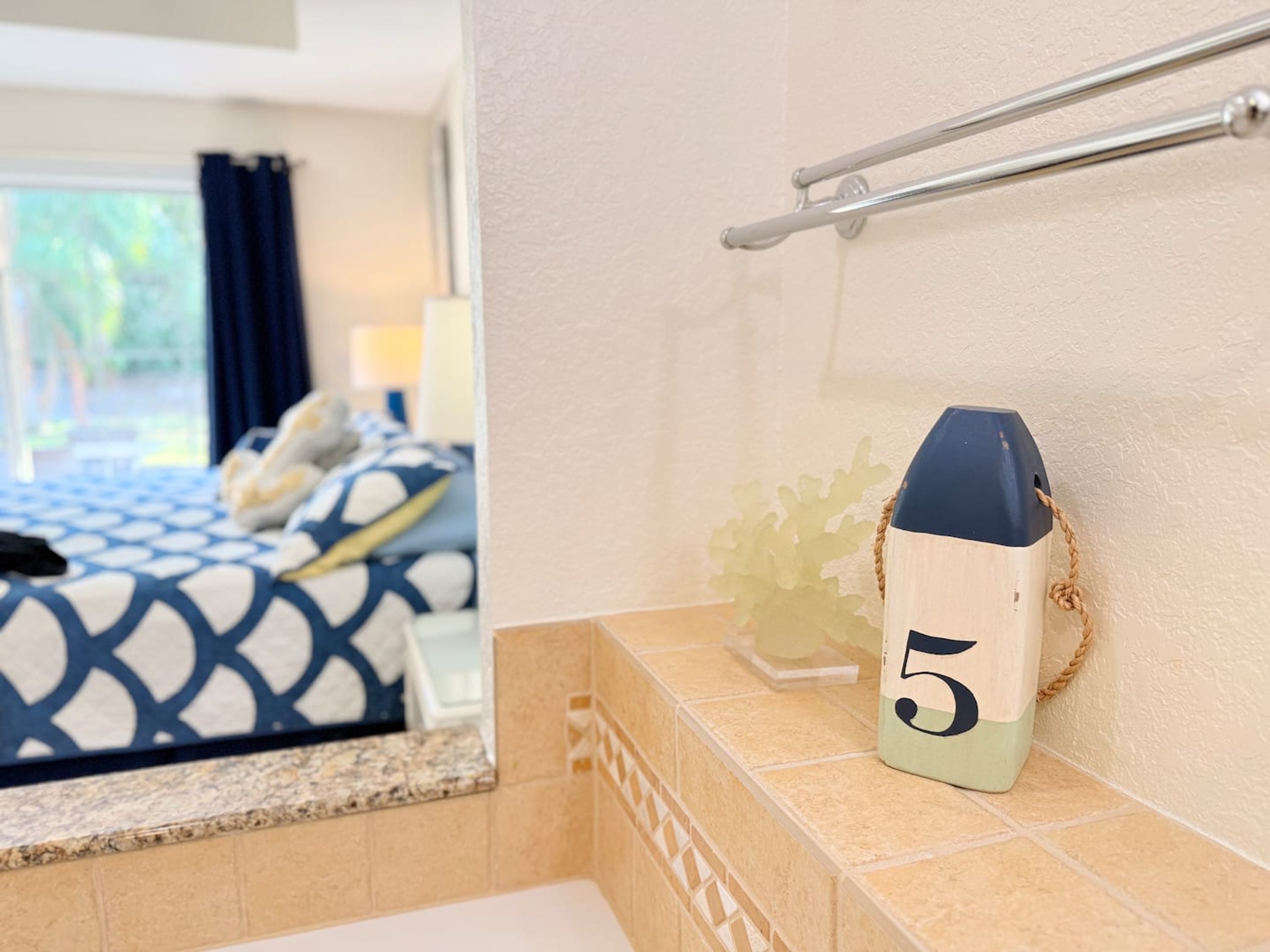 Une salle de bain avec une baignoire, un porte-serviettes et un panneau décoratif portant le chiffre 5.