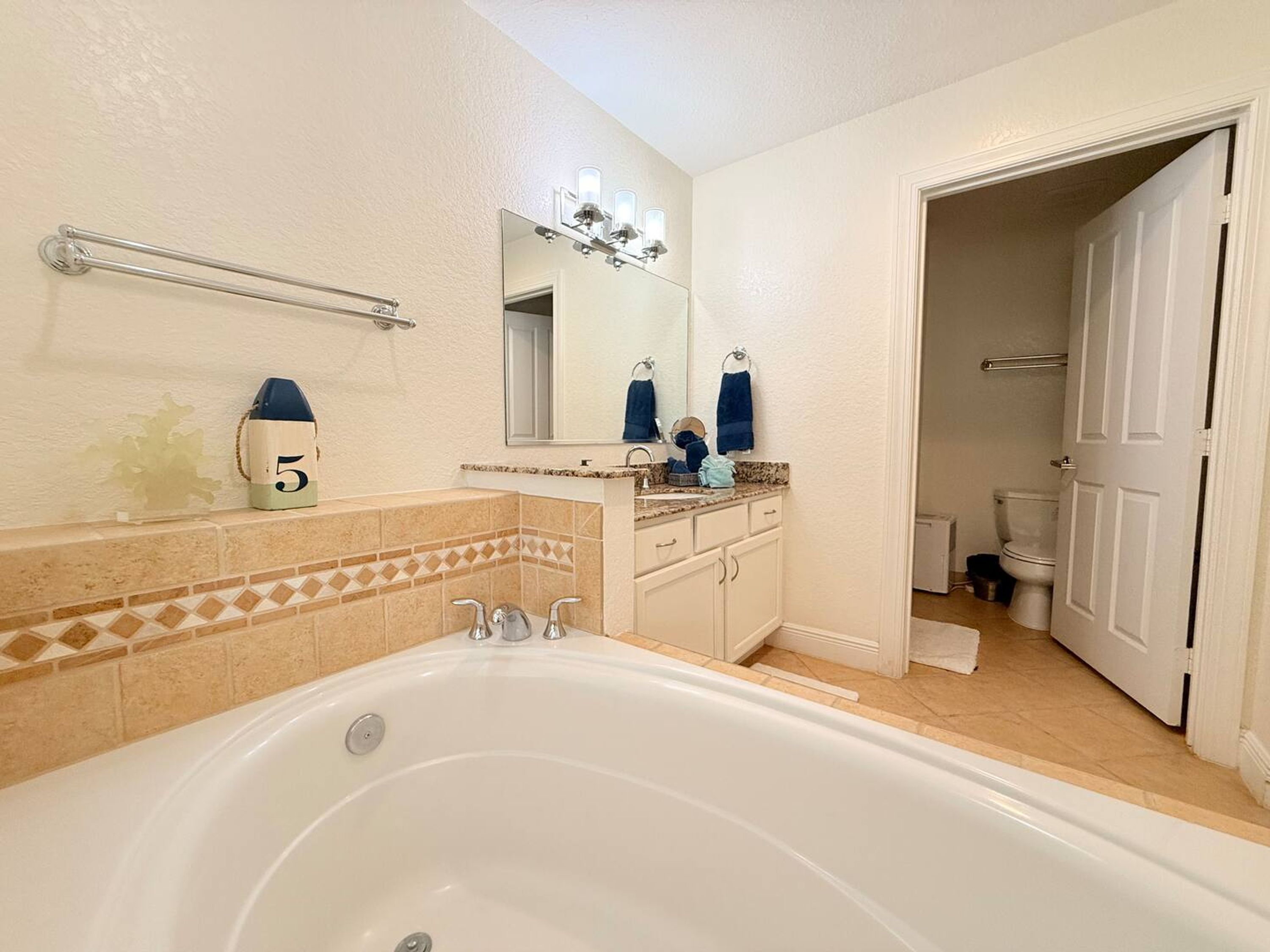A bathroom with a bathtub, a sink with a mirror, and a toilet.