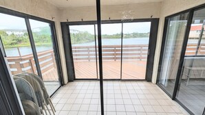 Ein Balkon mit Blick auf einen See und einer Holzterrasse.