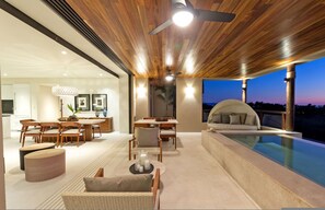 Un intérieur moderne comprenant un coin repas, des sièges et une piscine.