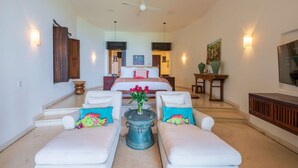 A spacious living area with a large bed, two sofas, a coffee table, and a ceiling fan. - Estate Venado in Punta Mita (Punta de Mita)