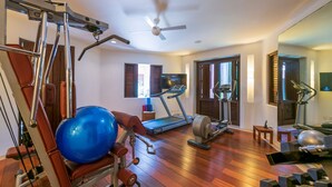 A home gym with exercise equipment, a treadmill, and a ceiling fan. - Estate Venado in Punta Mita (Punta de Mita)