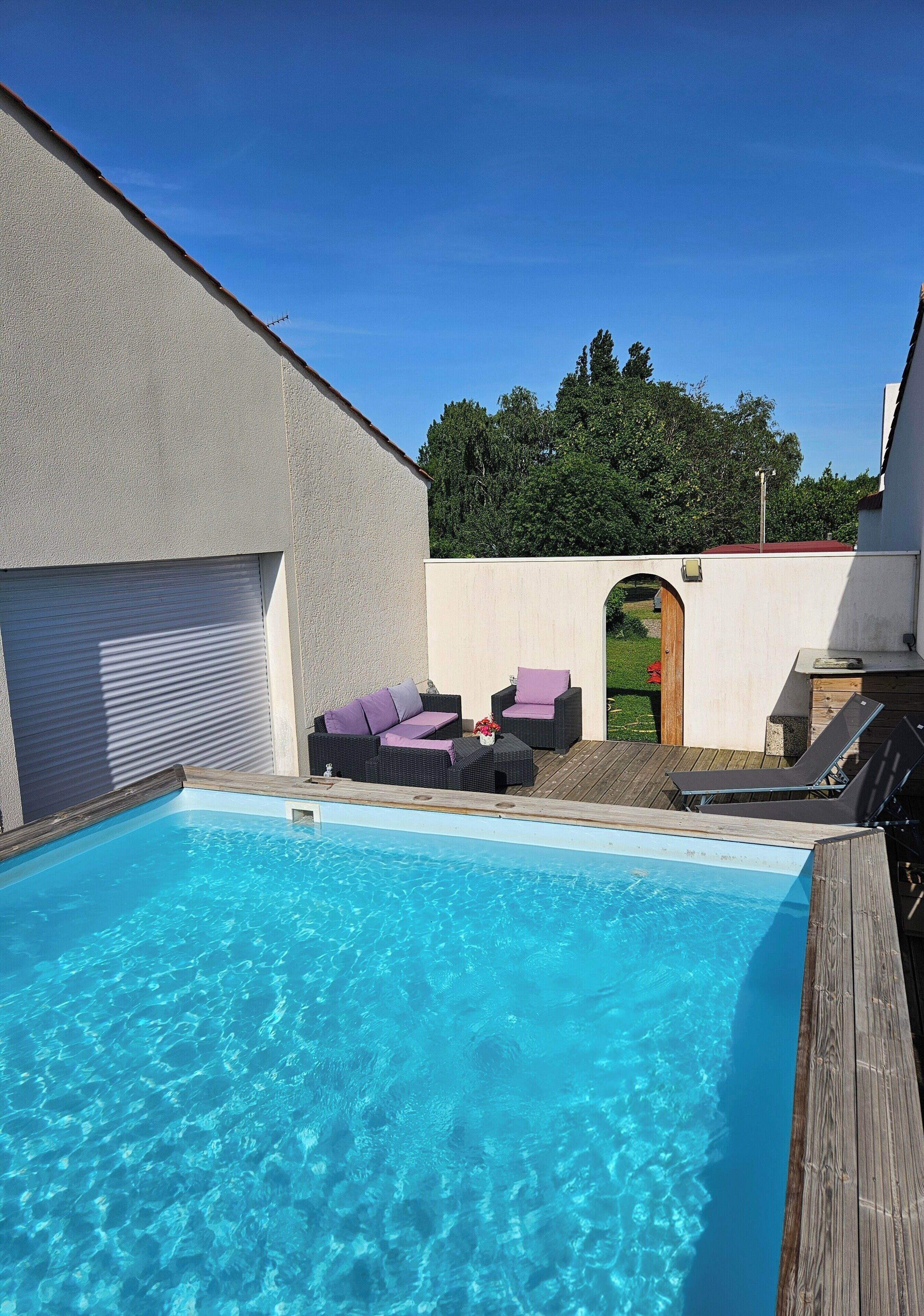 Ein Schwimmbecken mit Liegestühlen und einer Holzterrasse.
