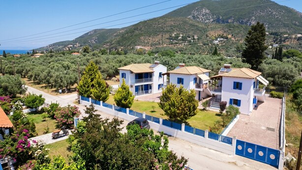 Zona residencial con casas, una carretera y montañas al fondo.