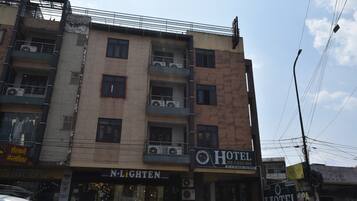 A multi-story hotel with balconies, a visible sign for 'N-Lighten,' and a 'Hotel Me-Casa Inn' sign.
