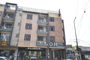 Un edificio de varios pisos con un hotel llamado 'Hotel Me-Casa Inn' en la planta baja.