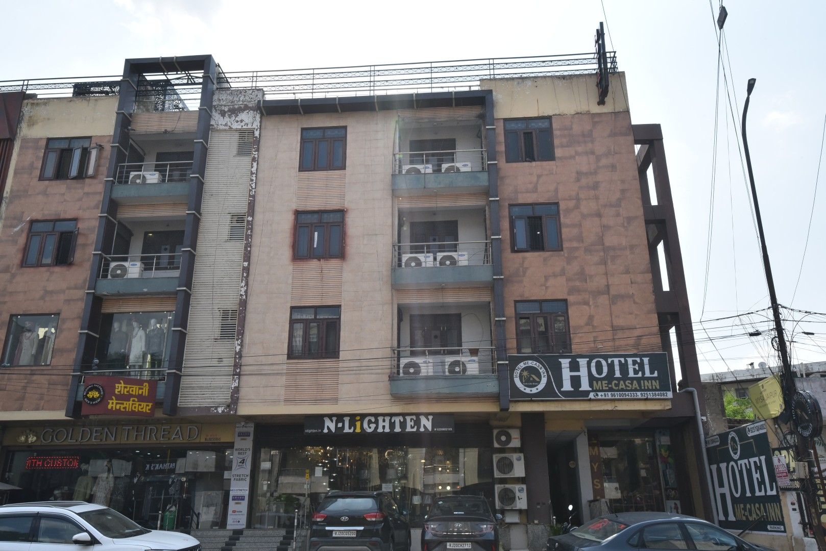 A multi-story building with a hotel named 'Hotel Me-Casa Inn' on the ground floor.