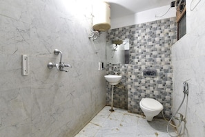 Un baño con inodoro, lavabo y ducha.