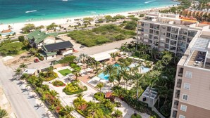 A resort with a pool, beachfront, and high-rise buildings. - Oceanfront 2BR Condo Le Vent 309 by Bocobay (Noord)