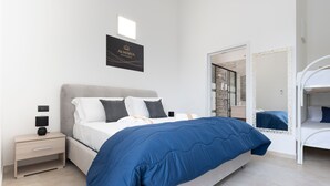 Ein modernes Hotelzimmer mit Bett, Nachttisch und Spiegel.
