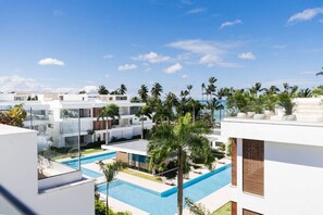 Ein modernes Resort mit Pool, Palmen und strahlend blauem Himmel.