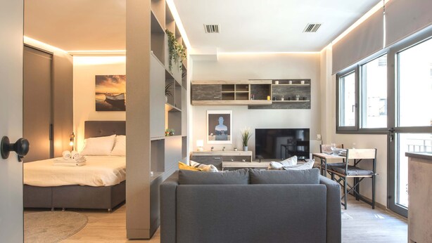 Une chambre d’hôtel moderne équipée d’un lit, d’un canapé, d’un coin repas et d’une cuisine.