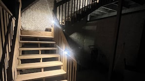 Una escalera de madera con barandillas metálicas que sube a un nivel superior.