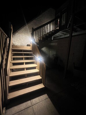 Eine Holztreppe mit Metallgeländern, die zu einer erhöhten Ebene führt.