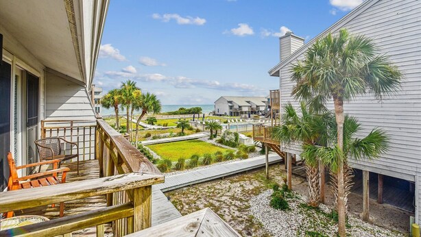 A coastal property with a wooden deck, outdoor seating, and a view of the ocean. - Welcome to Ocean Mile E-3! (St. George Island)