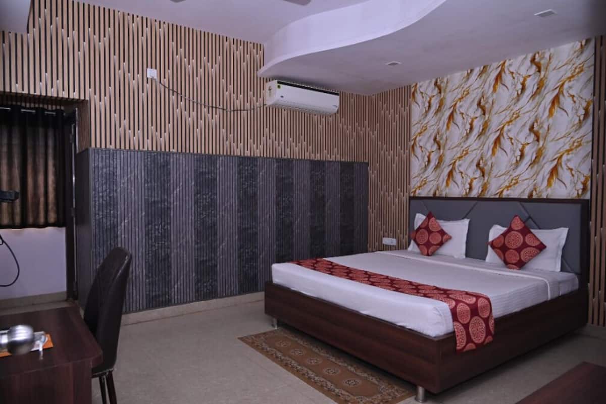 A bedroom with a bed, a desk, and a chair.