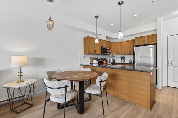 Una cocina moderna con armarios de madera, electrodomésticos de acero inoxidable y una isla central.