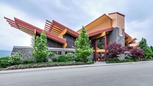 A modern building with a unique architectural design, featuring a prominent sloped roof and a stone facade. - Spectacular View 1 Bdrm 202 At Amenity Filled Resort (West Kelowna)