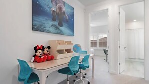 A room with a desk, chairs, a globe, and two plush toys. - Six months to 1 year Home in NONA on the Water, Gated Community, in Orlando, FL! (Orlando)