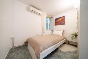 A bedroom with a bed, a window, a painting, and a nightstand. - House Sleeps 6 With Sea View and Parking (Thermaikos)