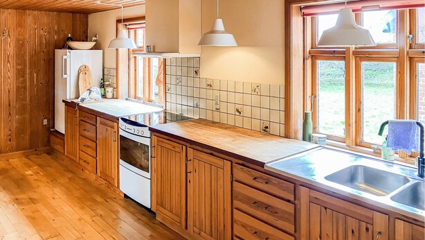 A kitchen with wooden cabinets, a stove, a sink, and pendant lighting. - 3 bedroom stunning home in Bedsted Thy (Bedsted Thy)