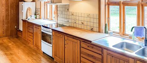 Cafetera o tetera, frigorífico, placa de cocina y utensilios de cocina