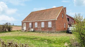 A red brick house with a tiled roof, a front door, and a garage. - 3 bedroom stunning home in Bedsted Thy (Bedsted Thy)