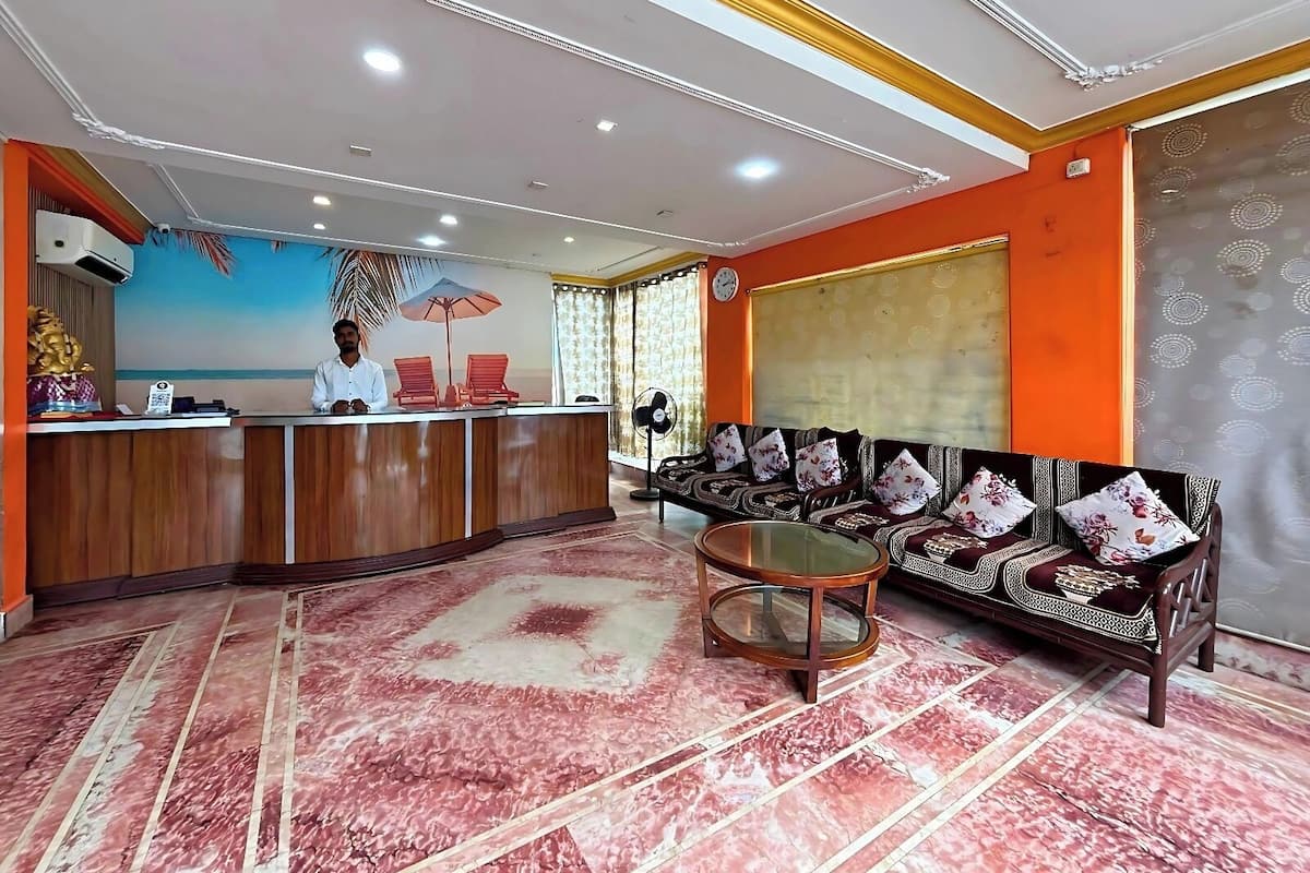 A reception area with a receptionist, a reception desk, a sofa set, a coffee table, and a patterned carpet.