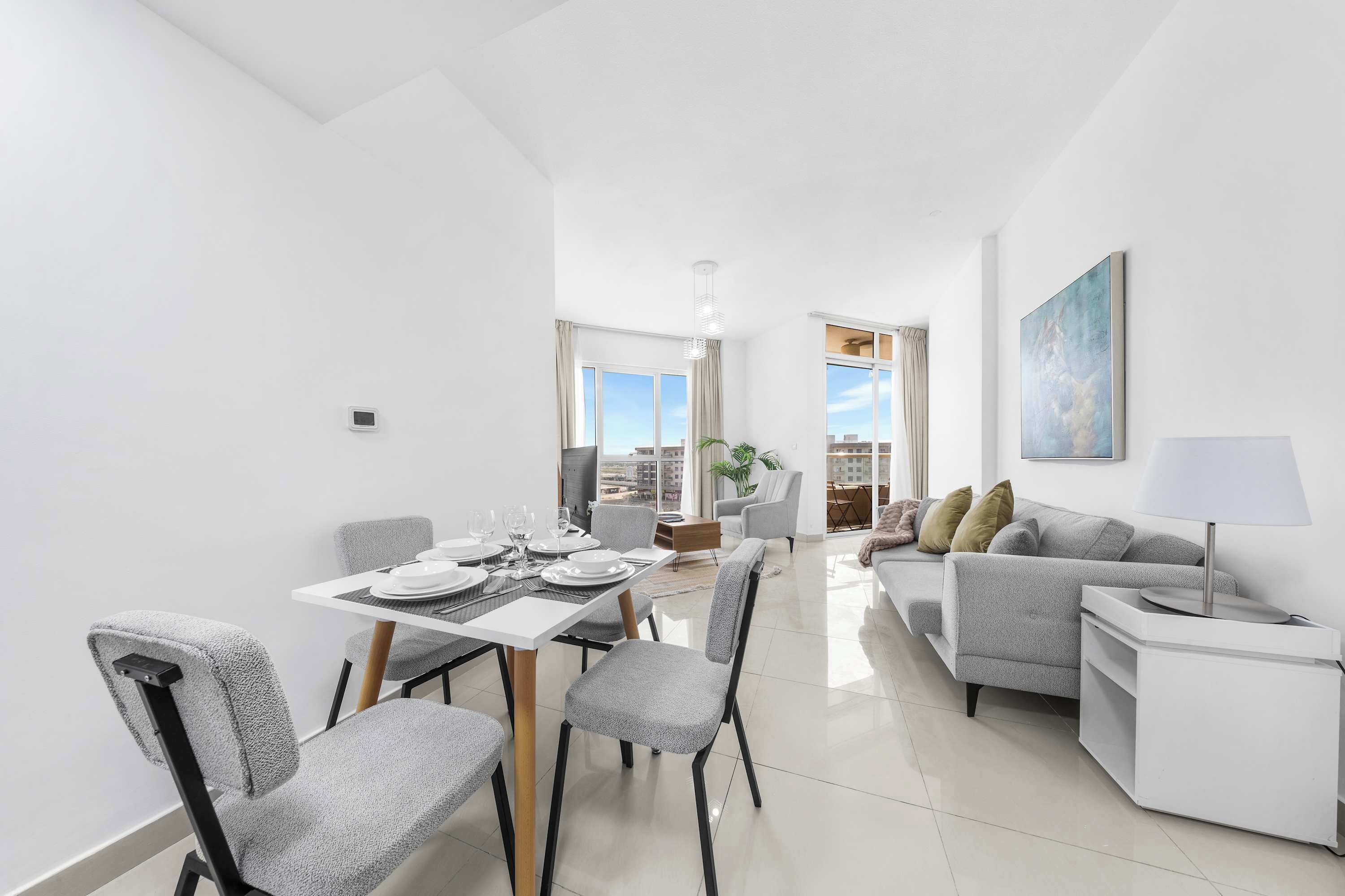 Una sala de estar moderna con comedor, un sofá y una lámpara.