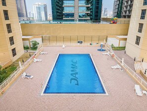 A rooftop swimming pool with a view of surrounding high-rise buildings. - StayShort - Comfortable 1 Bedroom in Production City that Sleeps 3! (Production City)