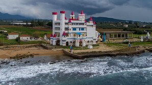 Un bâtiment ressemblant à un château, doté de plusieurs tours et situé près d’une étendue d’eau.