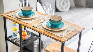 A dining table set with blue bowls and plates, a bottle, and glasses on a shelf. - Free Housekeeping Visits During Your Stay - Stayshort - 1 Bed in Business Bay With Modern Amenities That Sleeps 4 (Dubai)