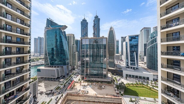 A high-rise building with multiple balconies, a central glass structure, and surrounding modern architecture. - Free Housekeeping Visits During Your Stay - Stayshort - 1 Bed in Business Bay With Modern Amenities That Sleeps 4 (Dubai)