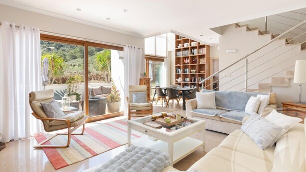 A modern living room with a sofa, armchair, coffee table, and a staircase. - La Manga Club Atalayas II Villa 616 (Cartagena)