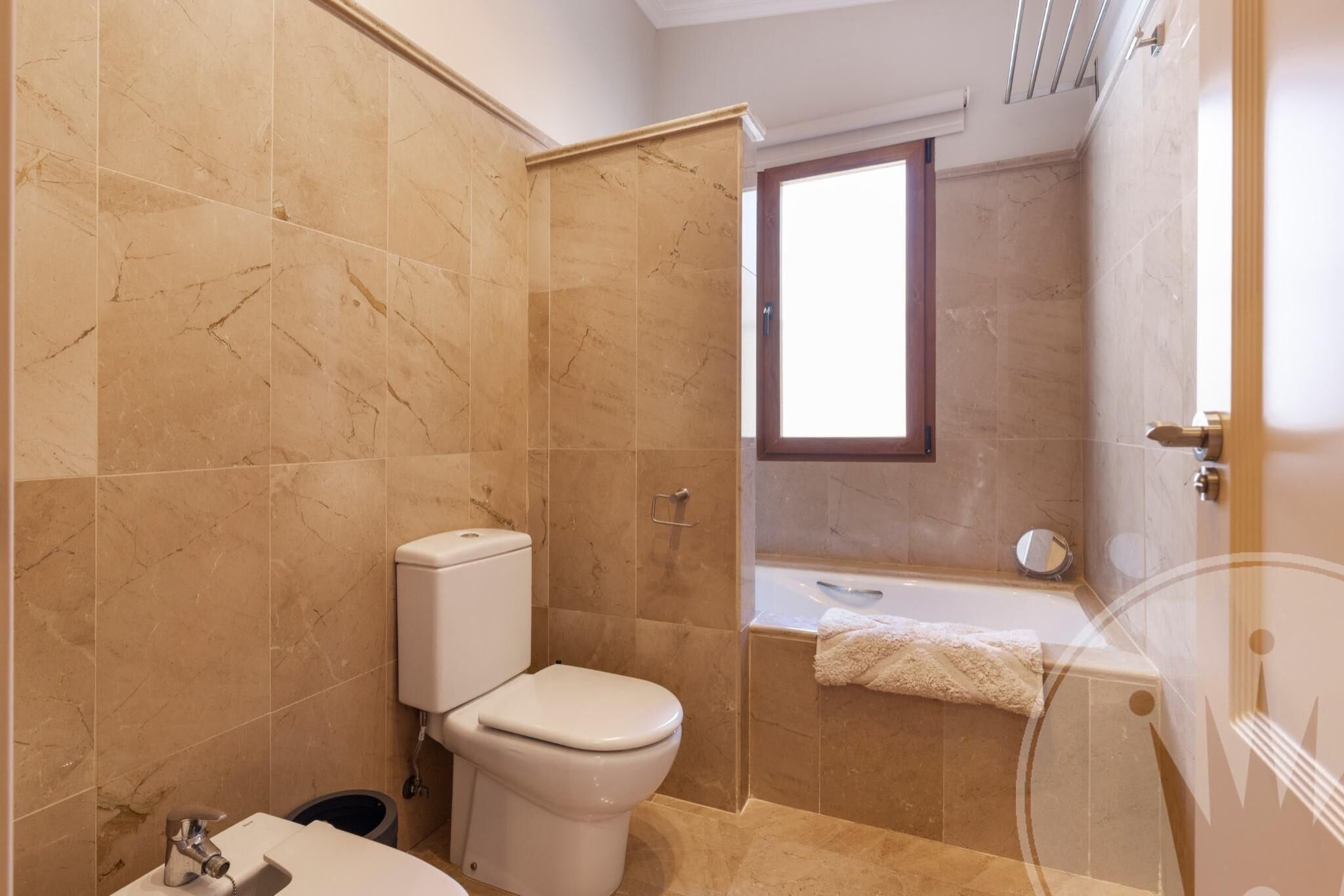 A bathroom with a toilet, sink, and bathtub.