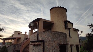 A stone building with a spiral staircase, a tower, and a view of the surrounding landscape. - Apartment Faro in Budoni (Budoni)