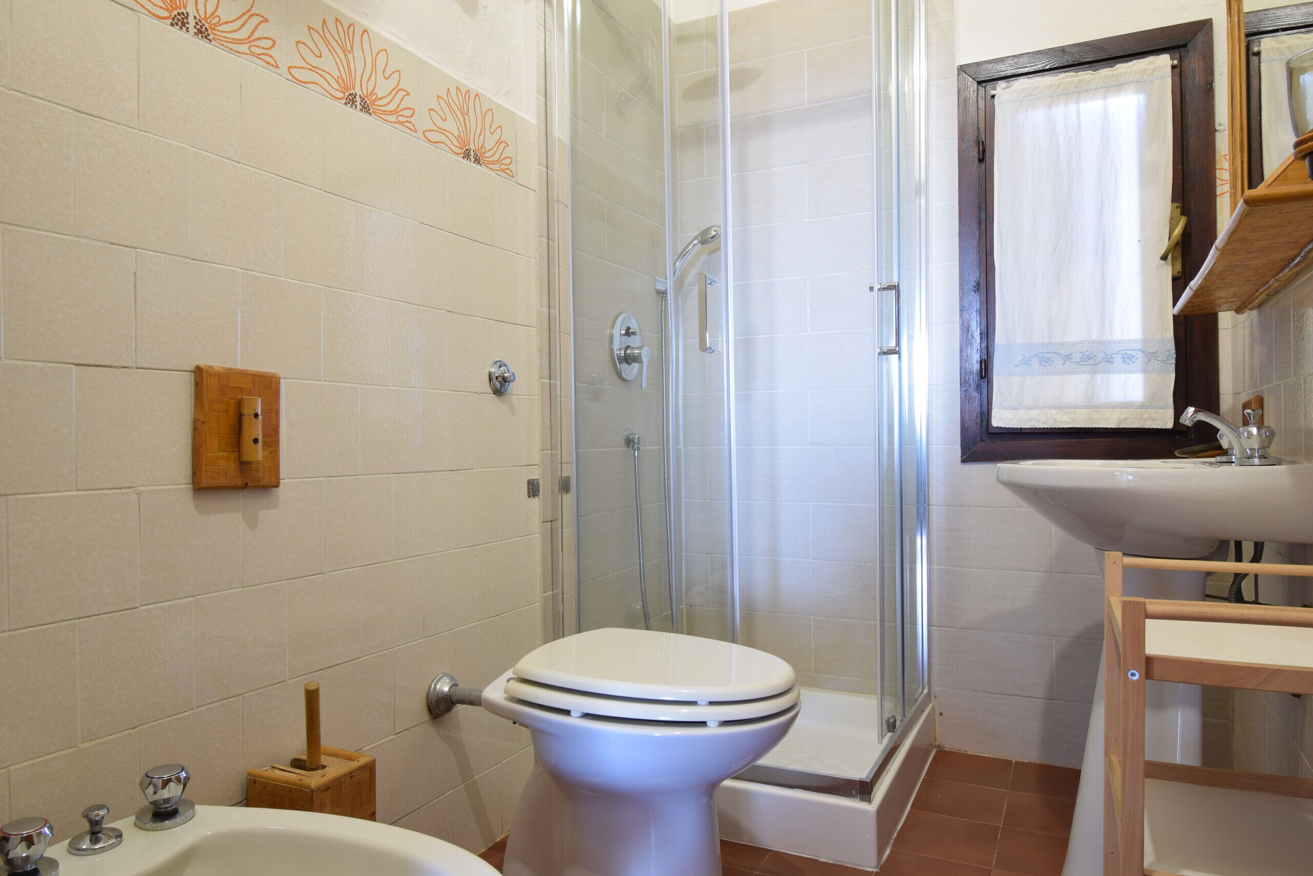 A bathroom with a toilet, shower, and sink.