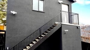 A modern two-story building with a staircase leading to a balcony. - "Avanta" with free parking near UofC (Calgary)