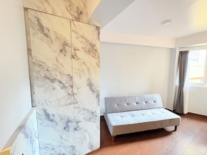 A room with a bed, a large wall panel, and a window with curtains. - Singalila Retreat Darjeeling (Darjeeling)