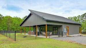 Een modern gebouw met een overdekte patio, een omheind honkbalkamp en een grindpad.