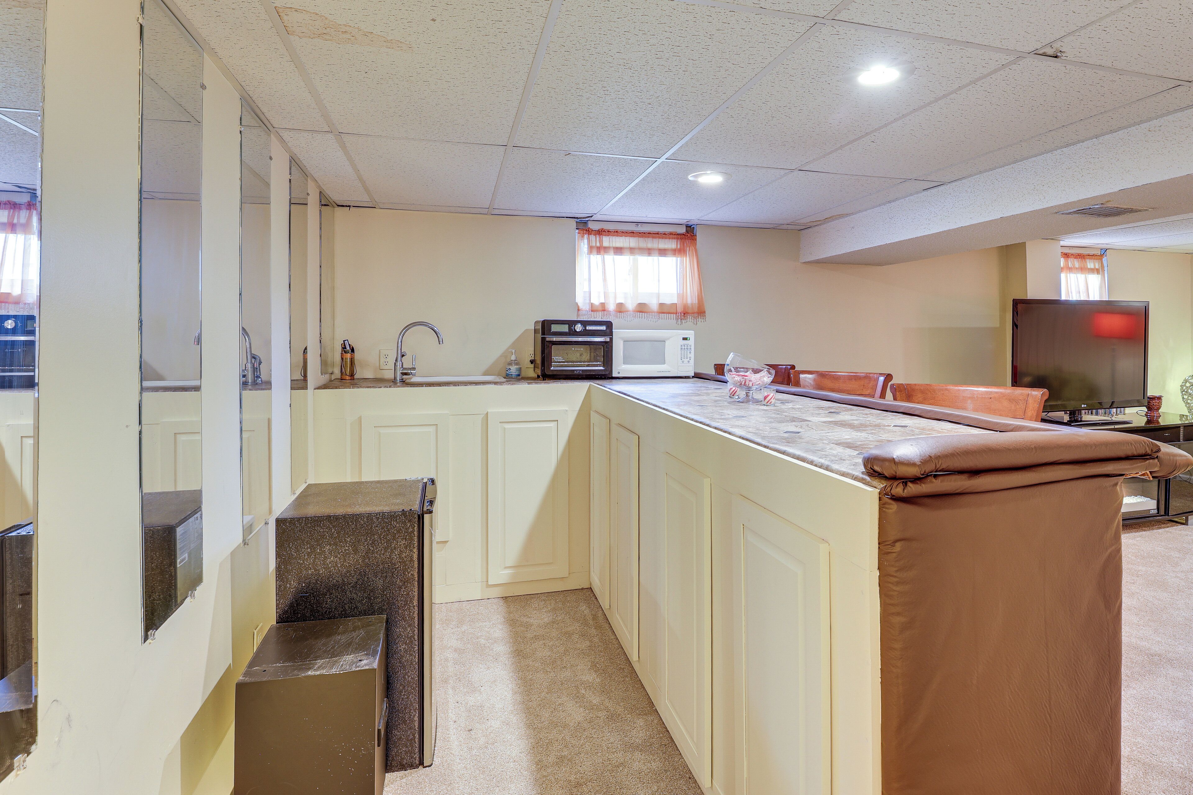 A kitchen with a microwave, sink, and cabinets.