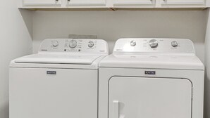 Two Maytag washing machines in a laundry room with white cabinets above. - Recently Remodeled Avondale Retreat, Private Yard! (Avondale)