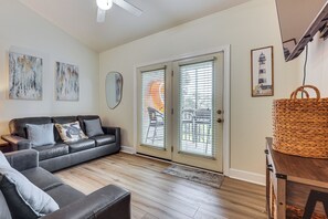 A living room with a sofa, a coffee table, and a wicker basket. - Pool Access! Recently Updated Coastal Retreat (Foley)