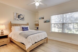 A bedroom with a bed, a ceiling fan, a nightstand, and a window with blinds. - Pool Access! Recently Updated Coastal Retreat (Foley)