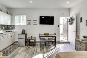 A modern kitchen with white cabinets, a refrigerator, a dining table with chairs, and a flat-screen TV mounted on the wall. - Pet Friendly, Private! Bonita Unit w/ Outdoor Pool (Bonita)
