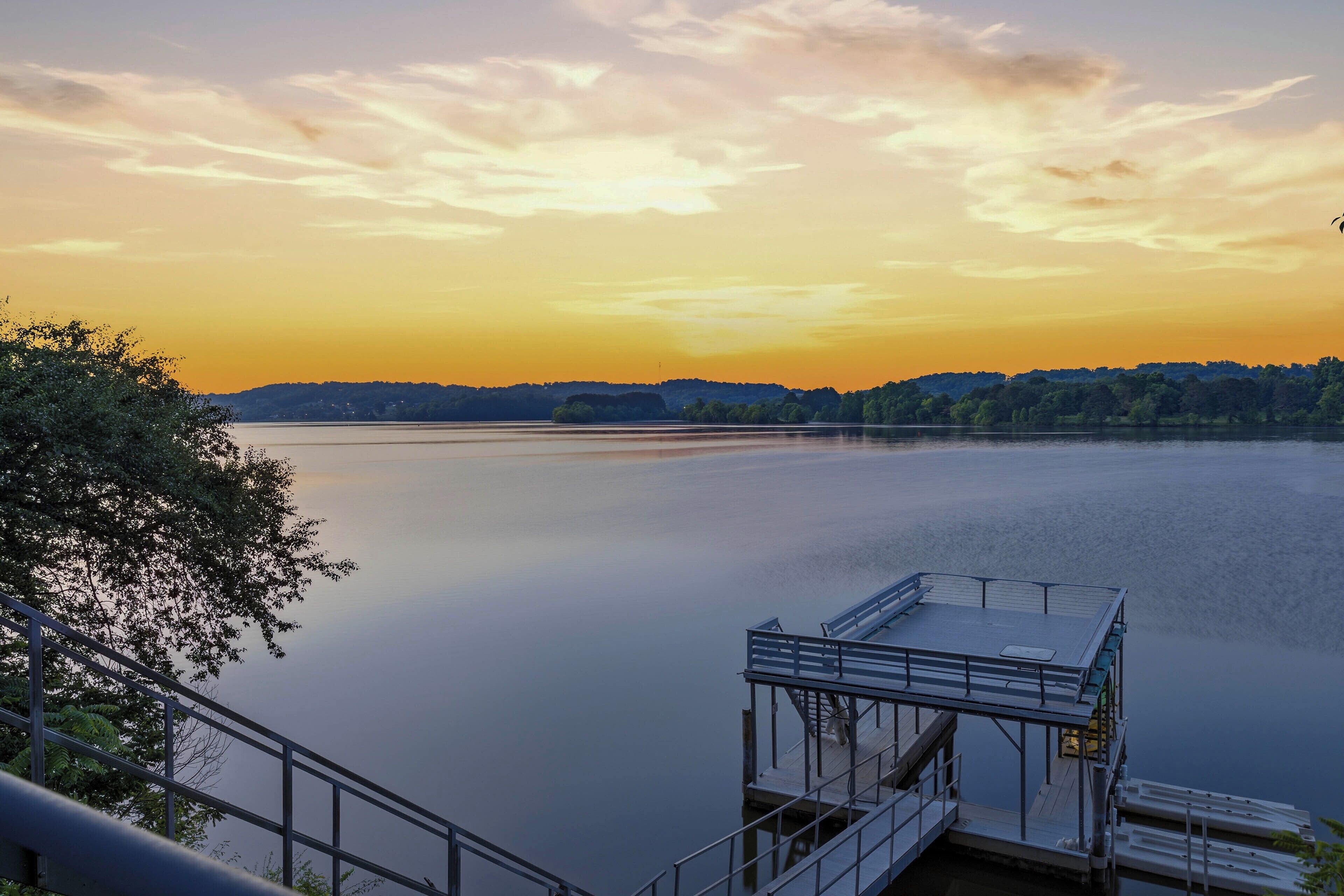 Ein ruhiger See mit einem Steg und einer Treppe, die zum Wasser hinunterführt.