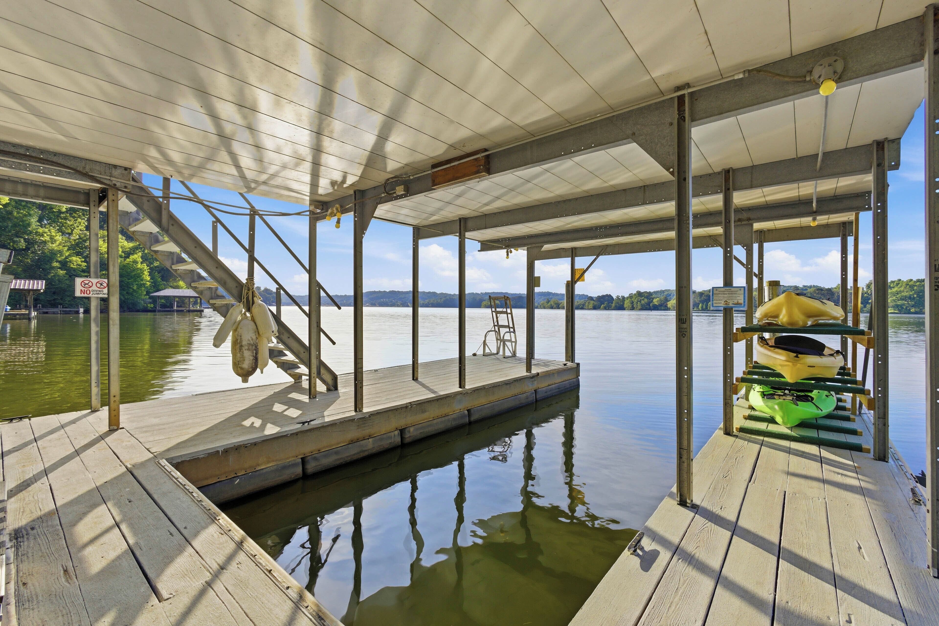 A dock with a covered area, a kayak, and a chair.