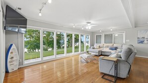 Amplia sala de estar con ventanas grandes, una chimenea moderna y un espacio de descanso acogedor.